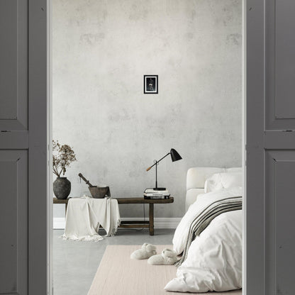 A bedroom with a white bed and a gray wall