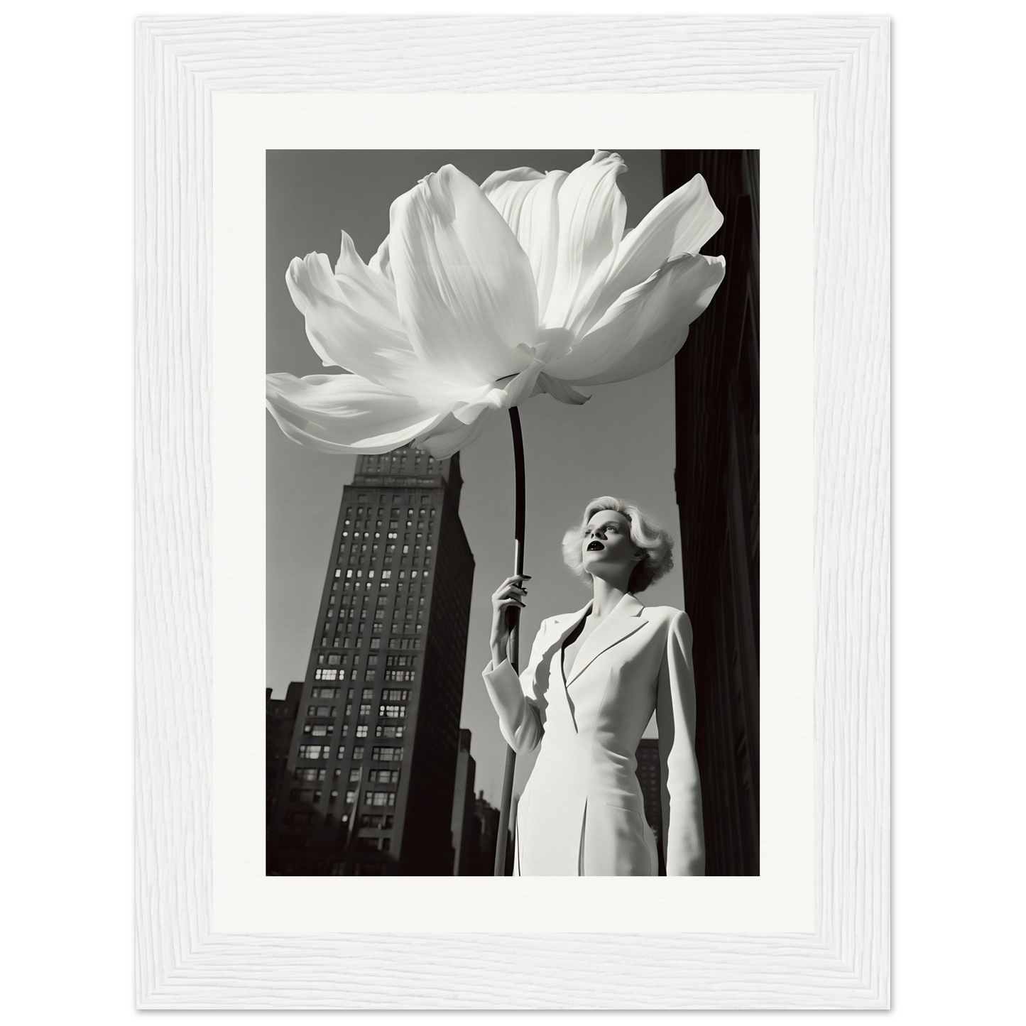 A black and white photo of a woman holding a large white flower