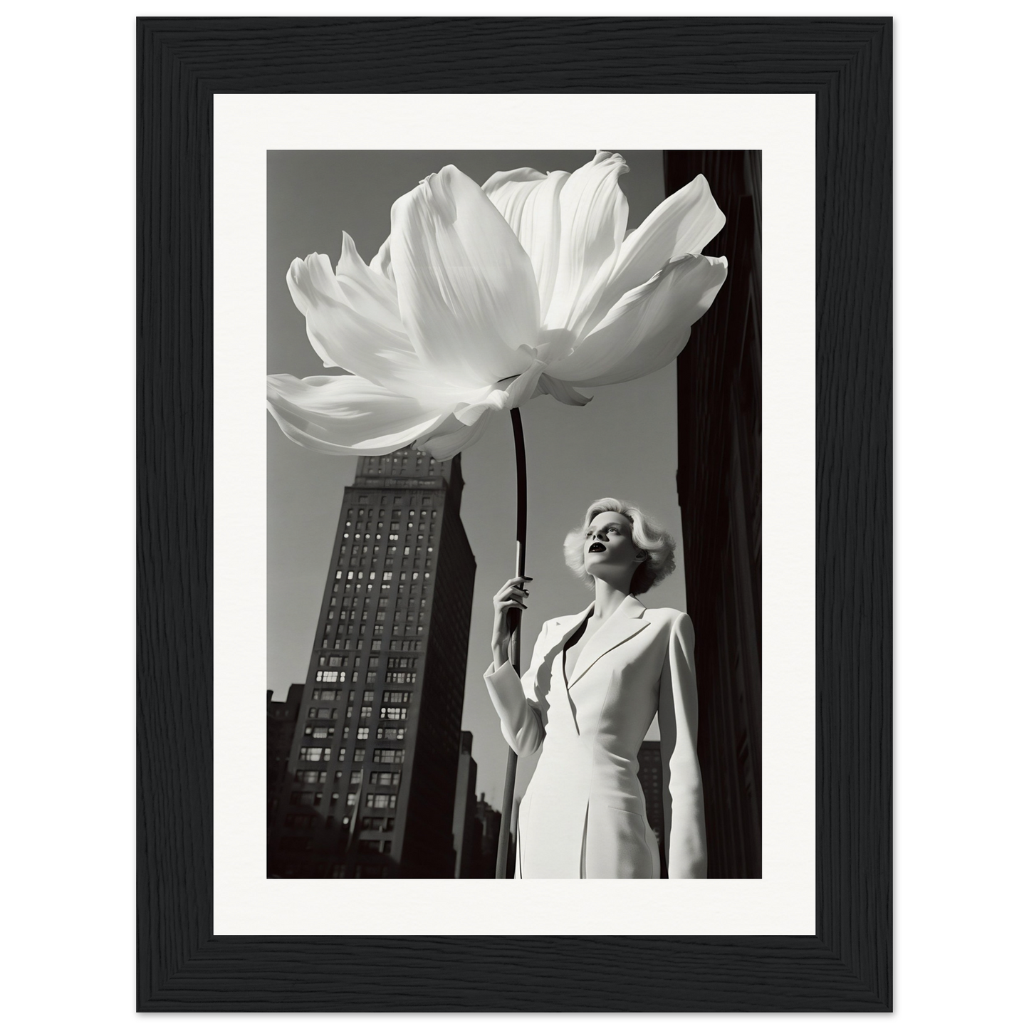 A black and white photo of a woman holding a large white flower