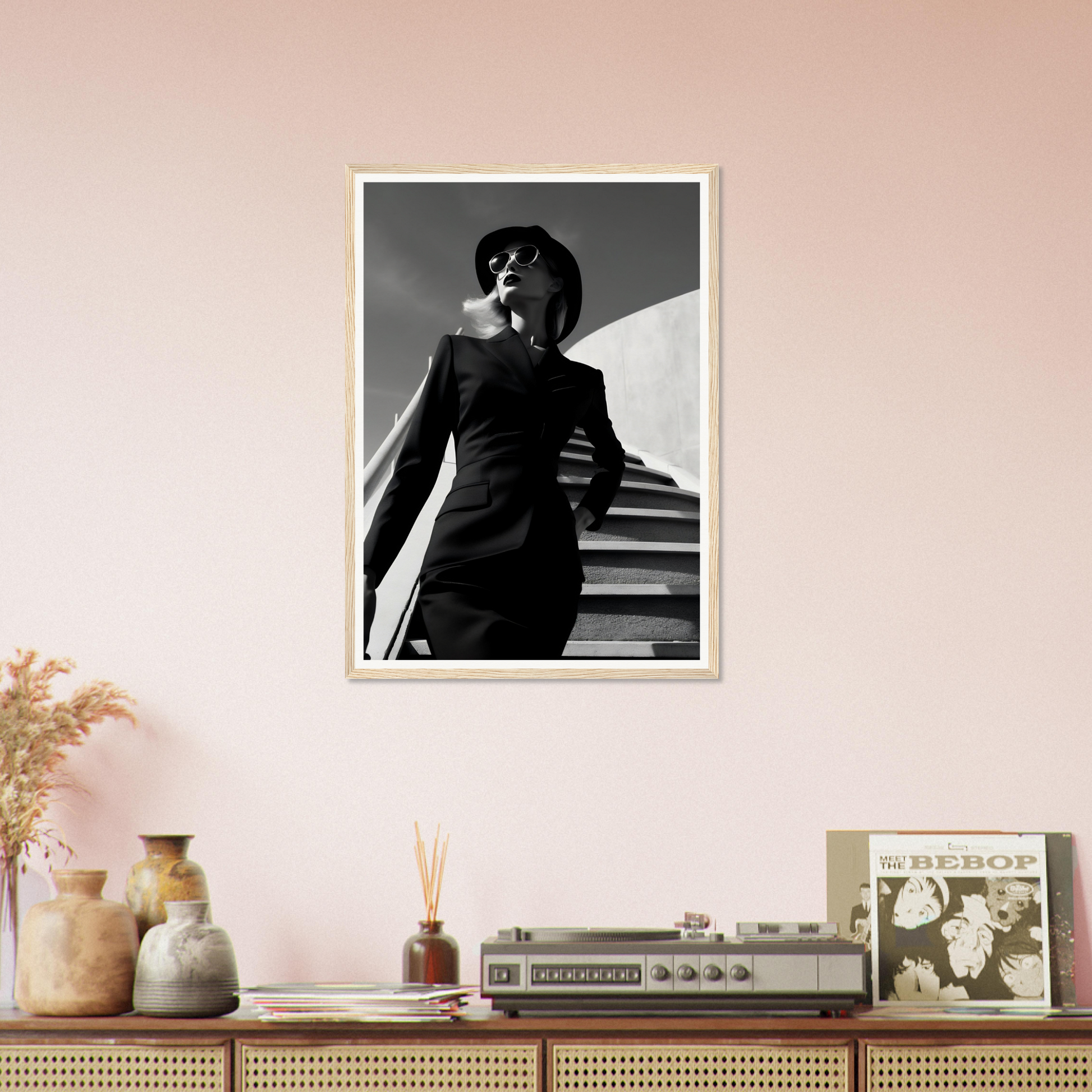 A black and white photo of a woman in a dress on a pink wall