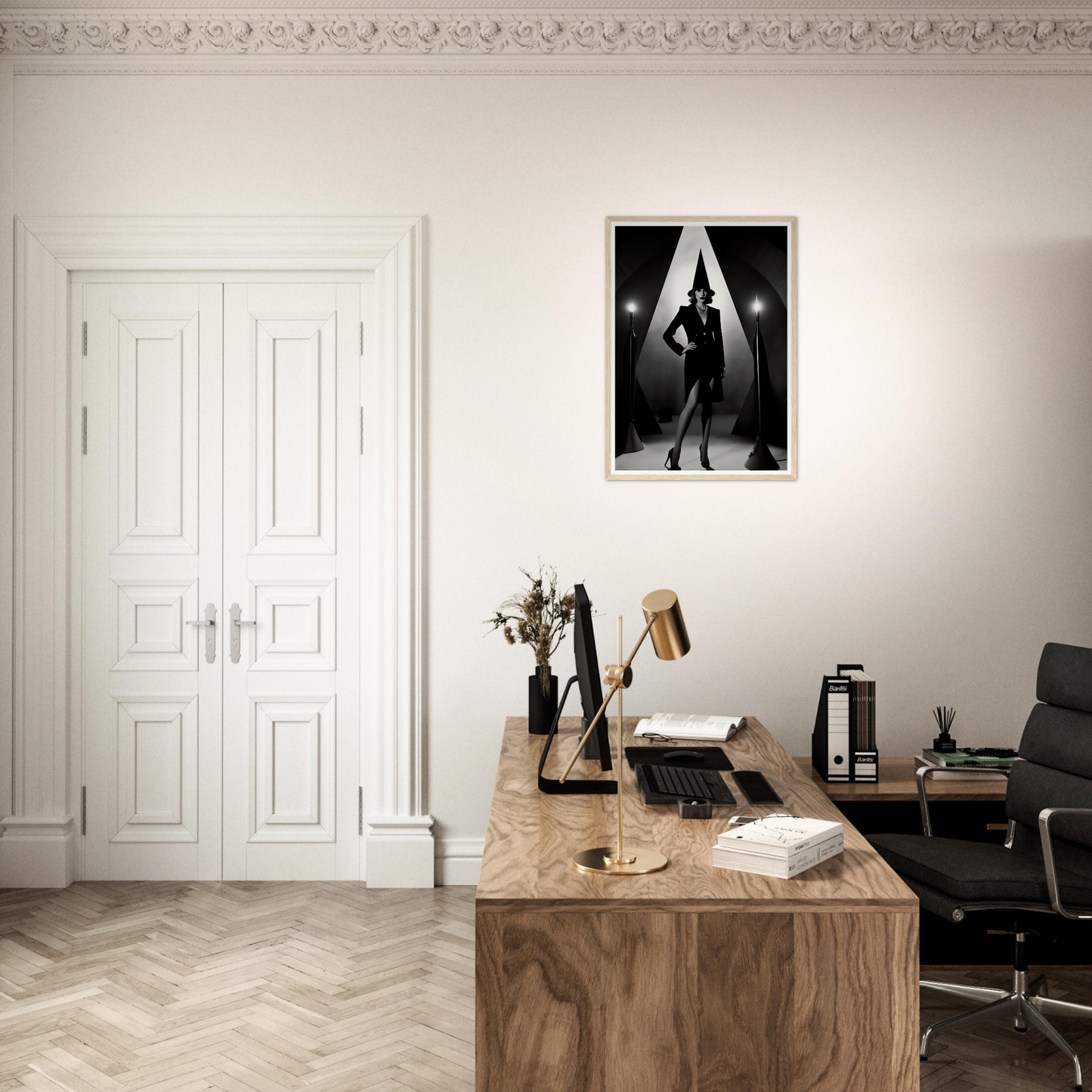 A black and white photo of a woman in a black dress on a wall above a desk