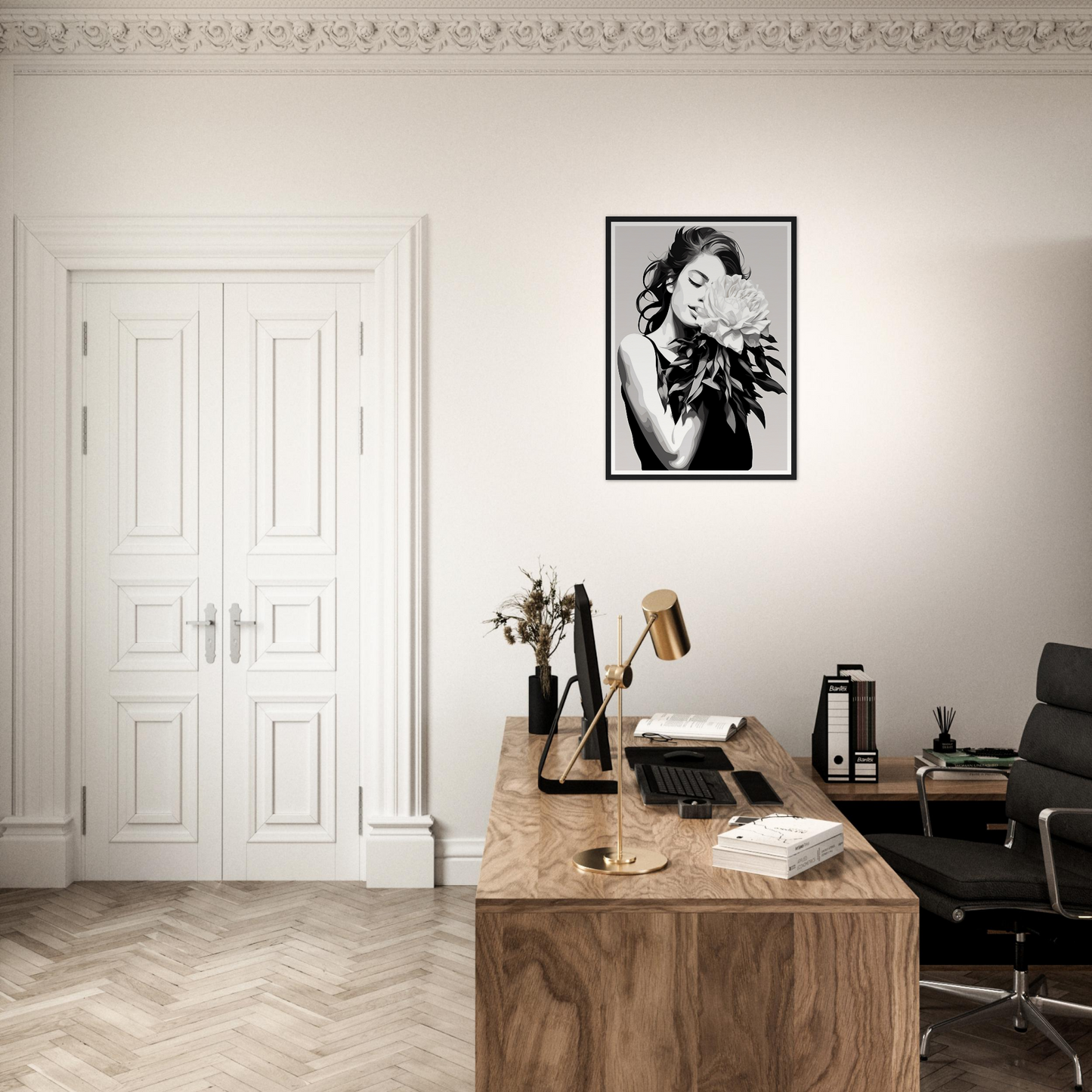 A black and white photo of a woman in a black dress on a wall above a desk