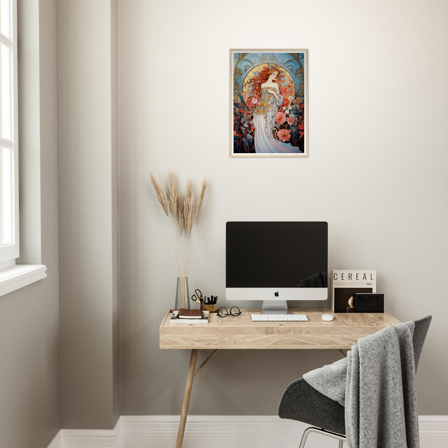 Minimalist wooden desk with a computer monitor, office supplies, and decorative artwork above.