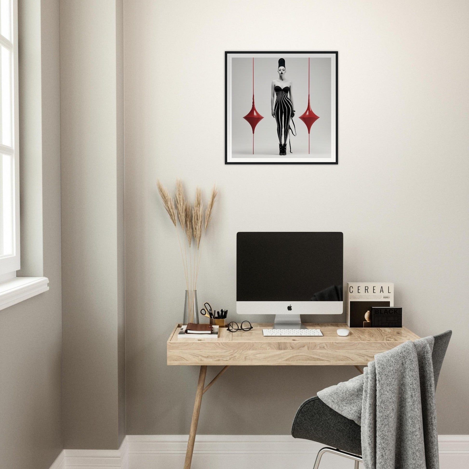 Minimalist home office workspace with a wooden desk, computer monitor, and decorative wall art.