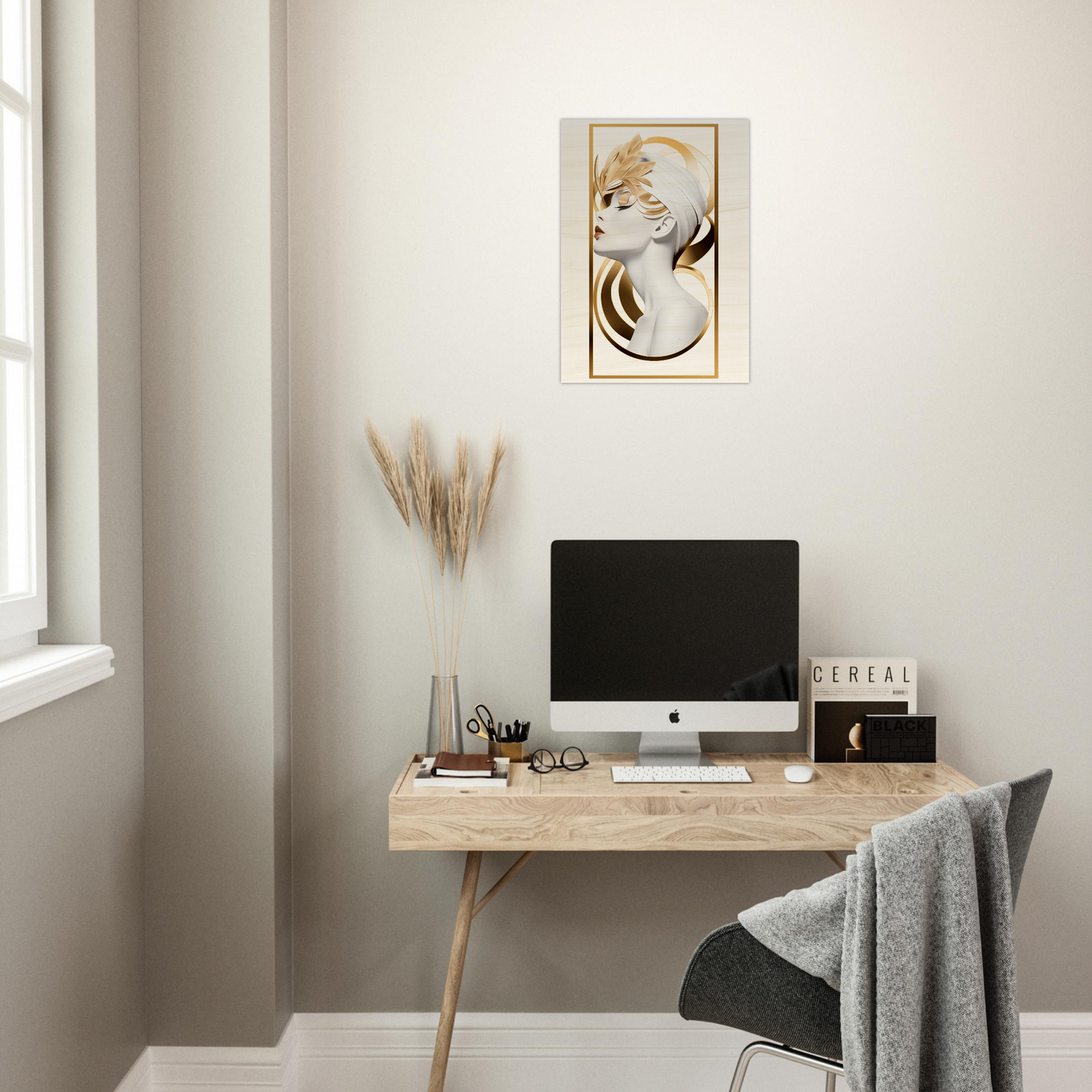 Minimalist home office workspace with a wooden desk, computer, and cat artwork on the wall.