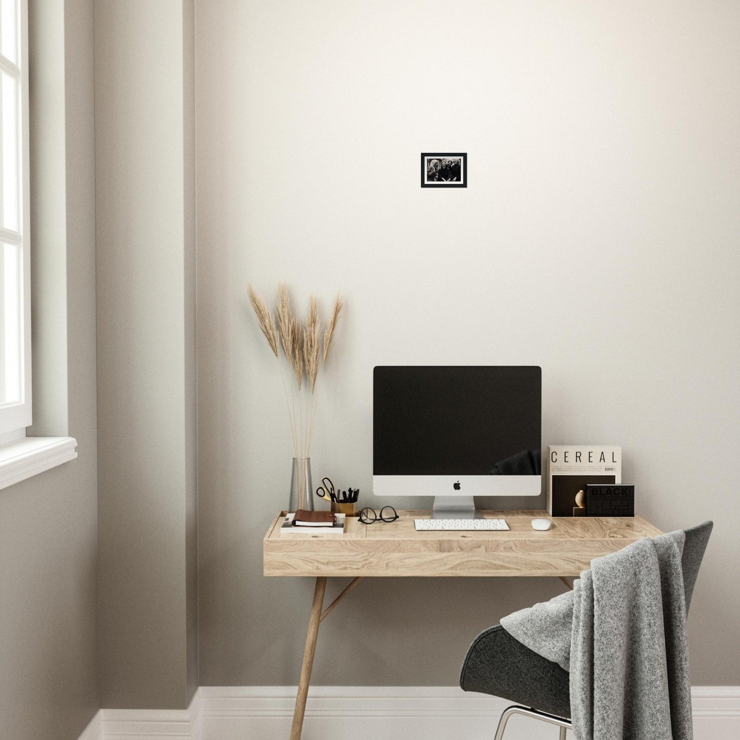 Minimalist wooden desk with a computer monitor and decorative accessories.