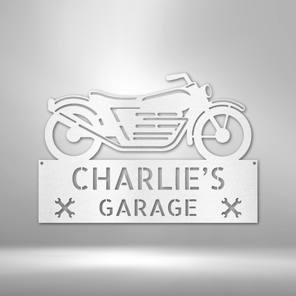 Motorcycle-shaped sign reading ’CHARLIE’S GARAGE’ with decorative elements.