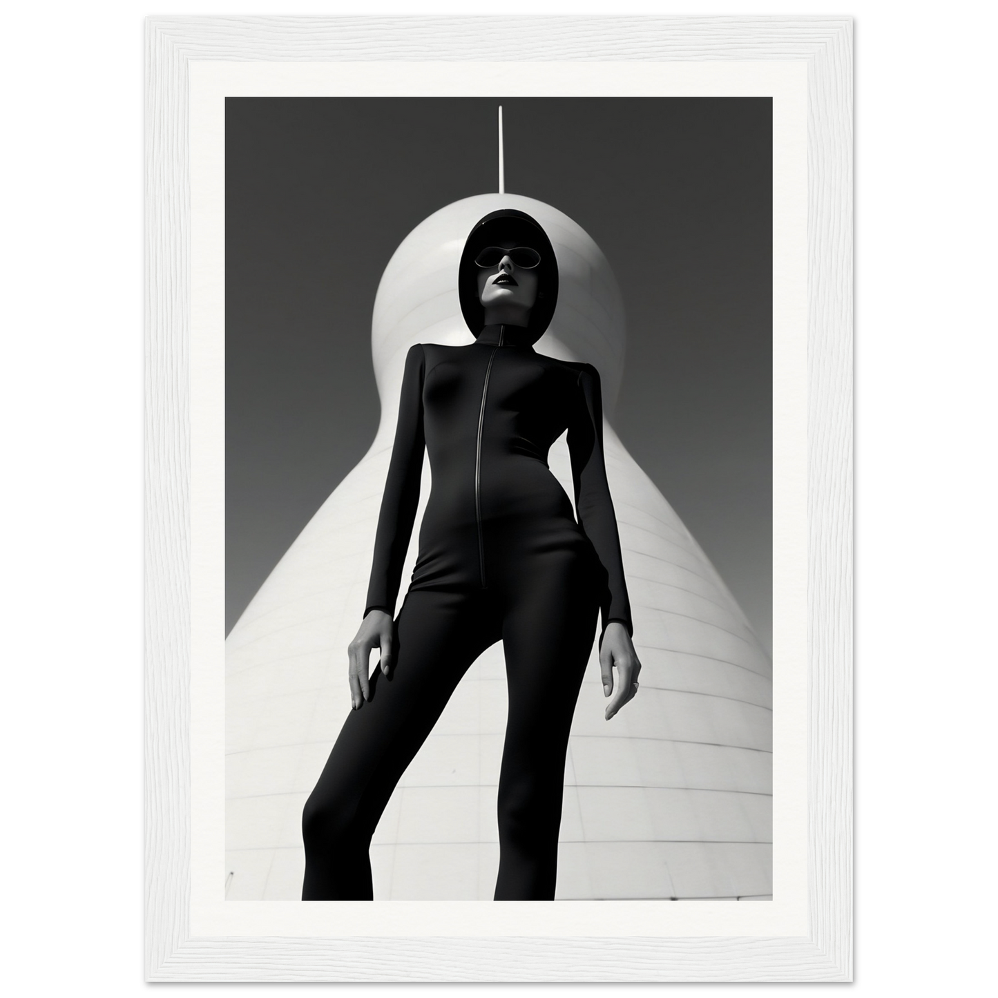 Silhouetted figure in a form-fitting black outfit standing against a stark white backdrop with dramatic lighting.