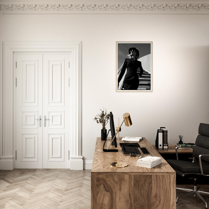 A desk with a chair and a framed photo on the wall