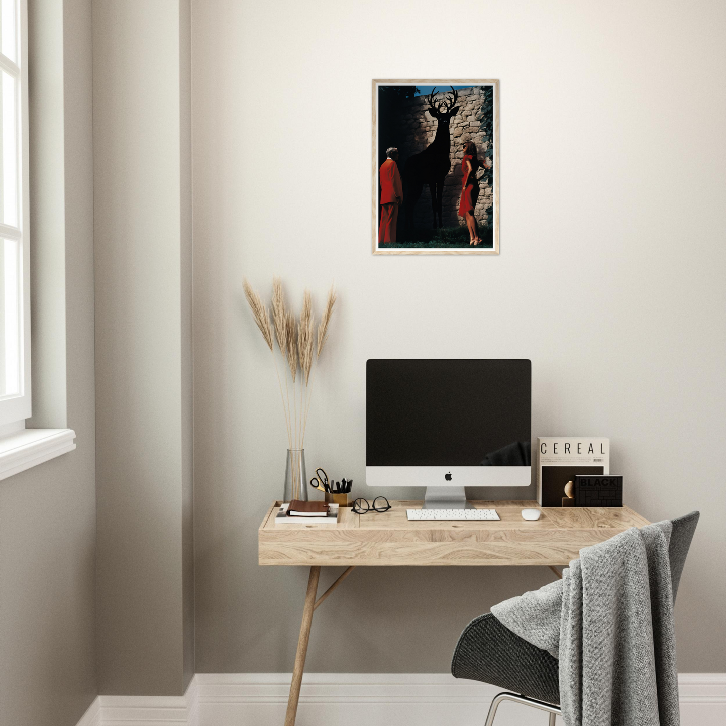 A desk with a computer and a painting on it