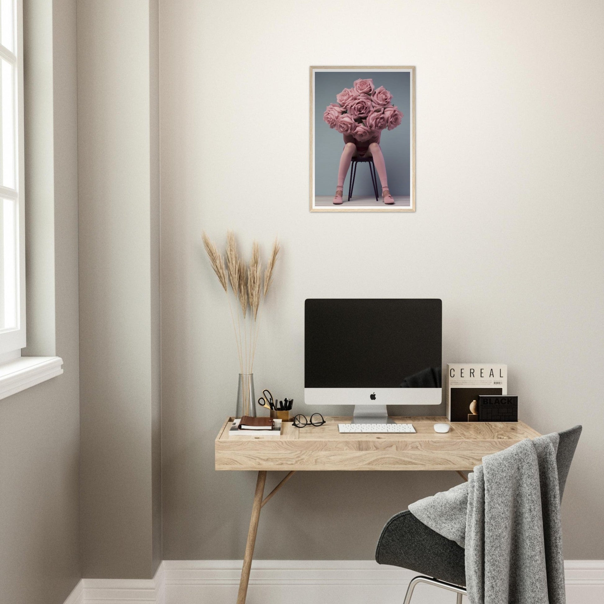 A desk with a computer and a pink flower