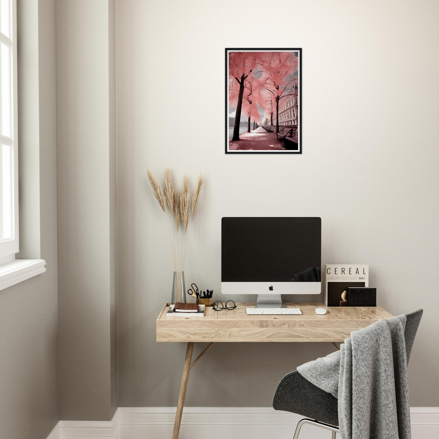 A desk with a computer and a pink painting on it