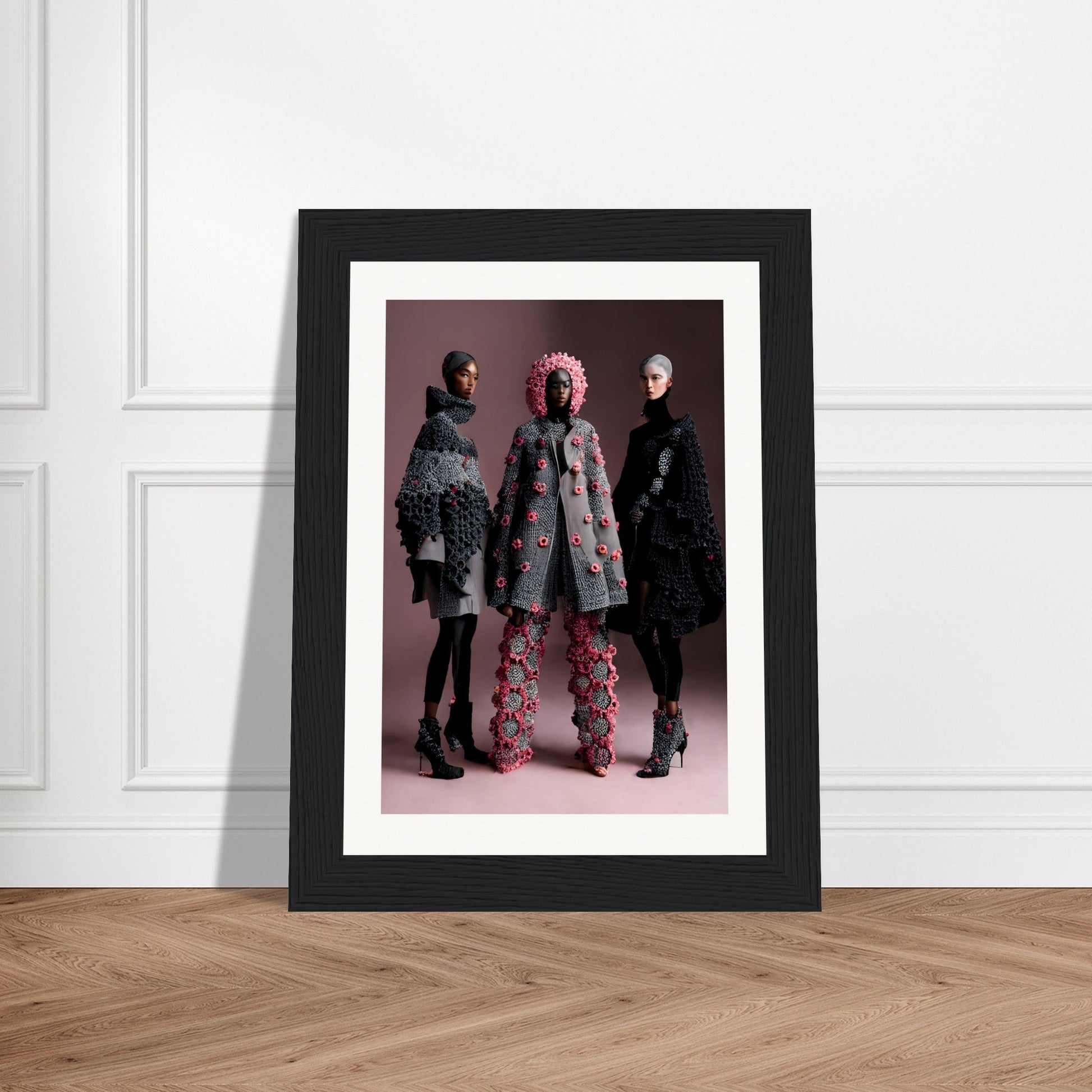 Framed photograph of three people wearing avant-garde fashion outfits.