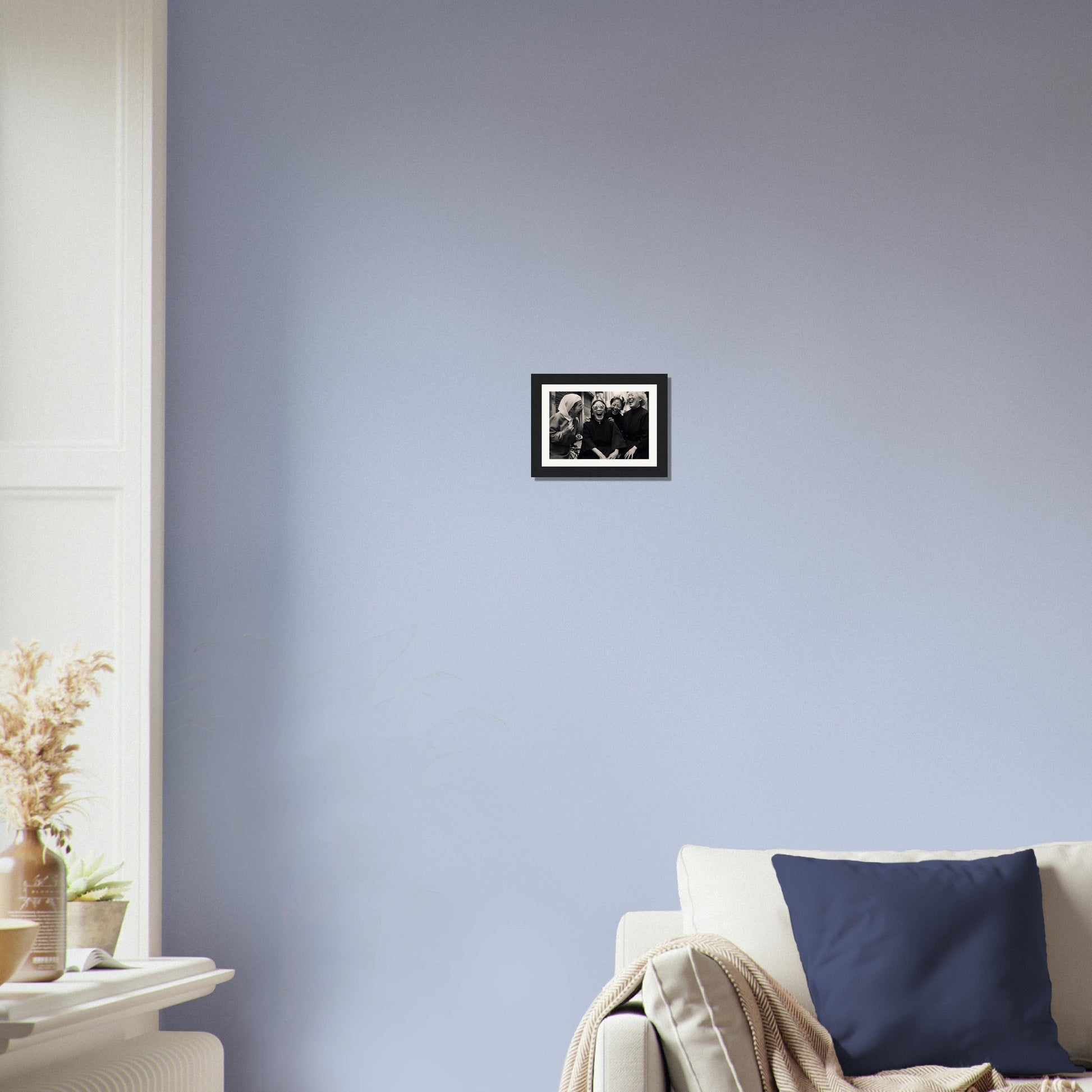 Framed black and white photograph hanging on a pale blue wall.