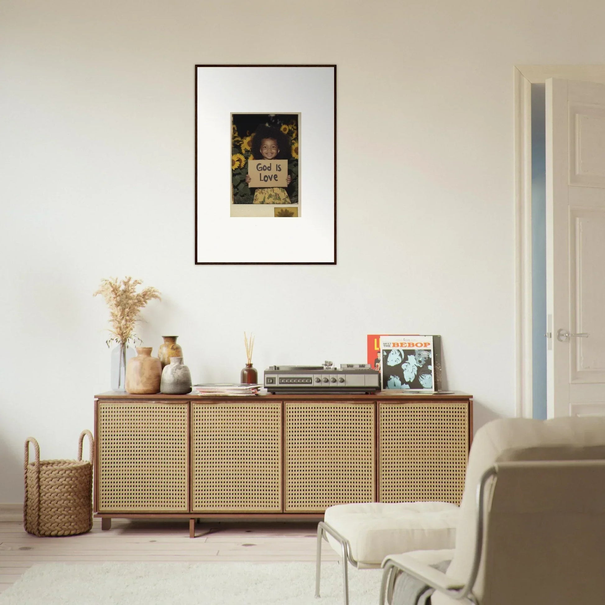 Stylish wooden sideboard with cane doors for room decoration and decorative canvas print