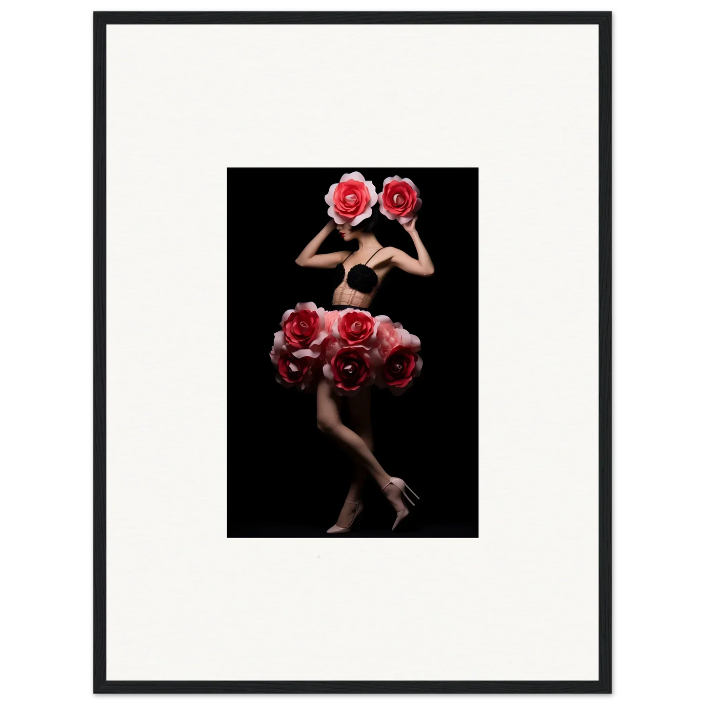 Artistic photograph of a figure composed of red roses against a black background.