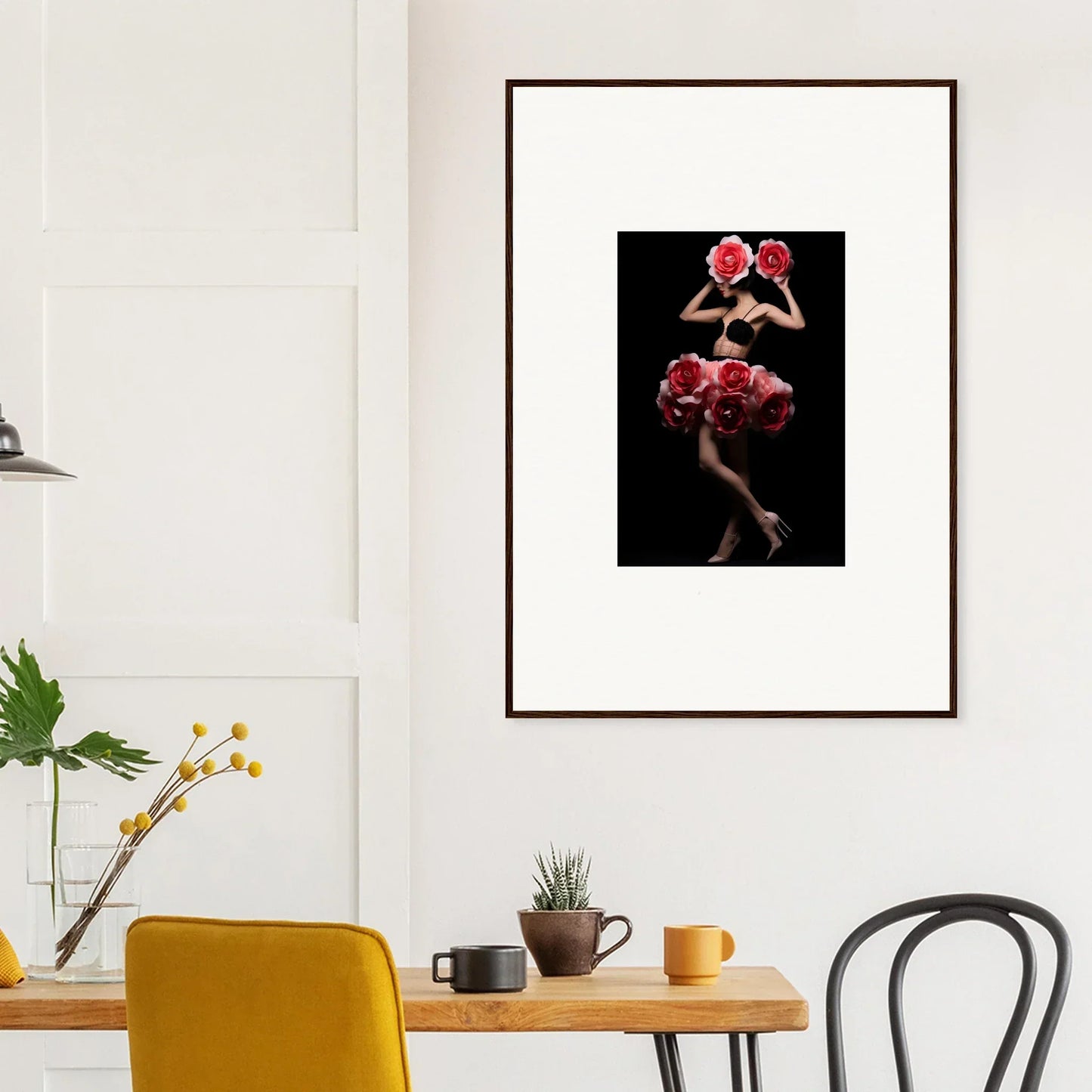 Framed photograph of a figure adorned with red flowers against a dark background.