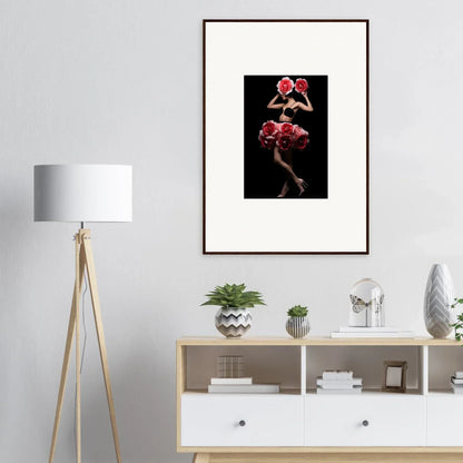 Framed artwork depicting a figure with red floral elements against a dark background.