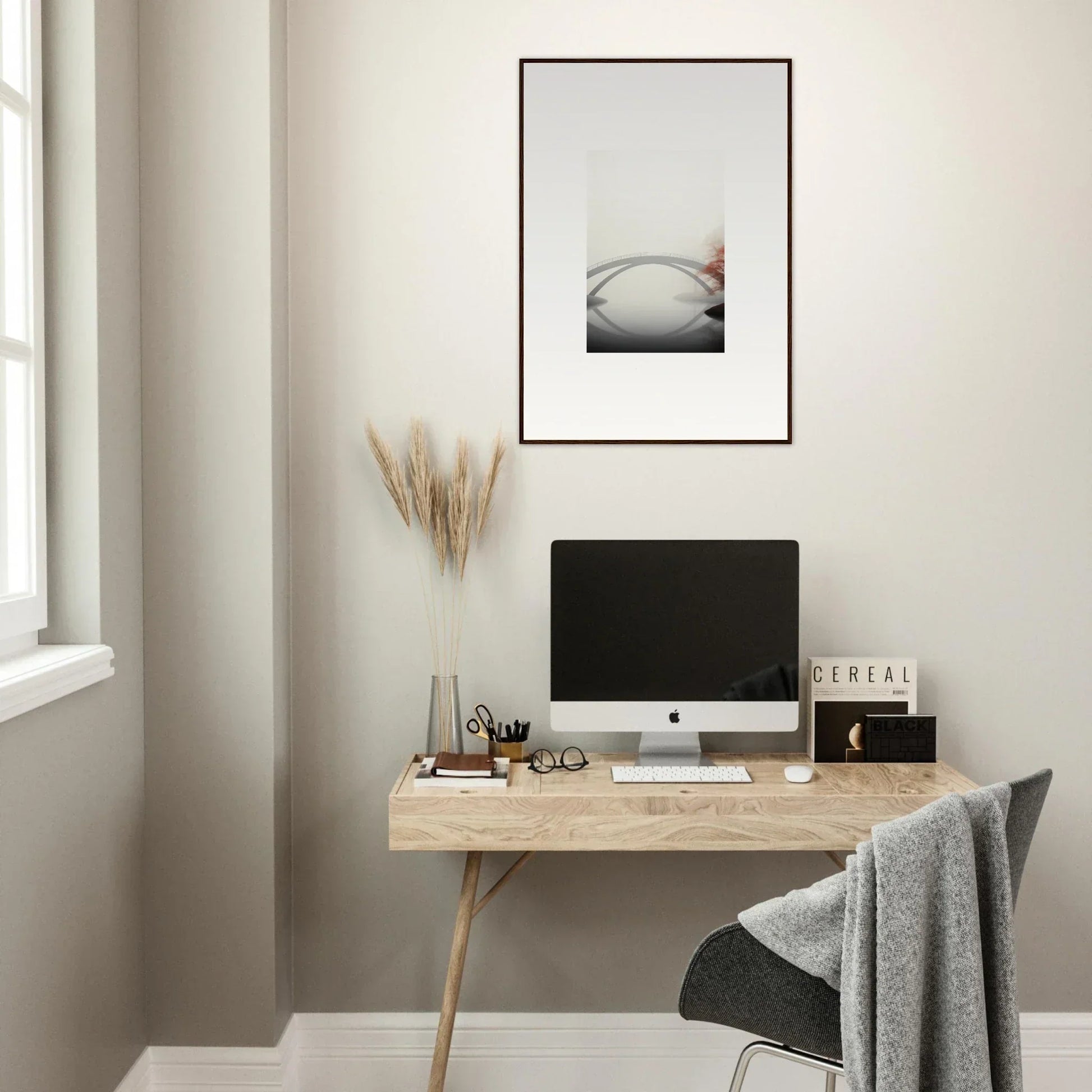 Minimalist home office with wooden desk, computer, and bridge reflection wall art decor