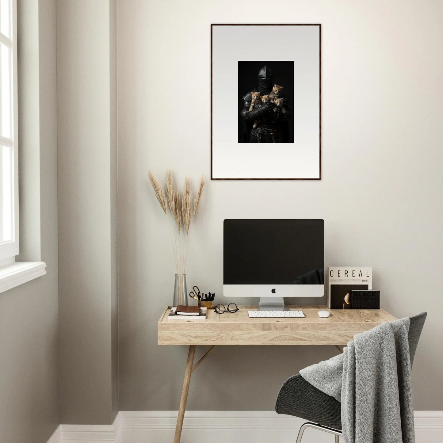 Minimalist wooden desk with computer monitor, tender fluff decor, and framed wall art