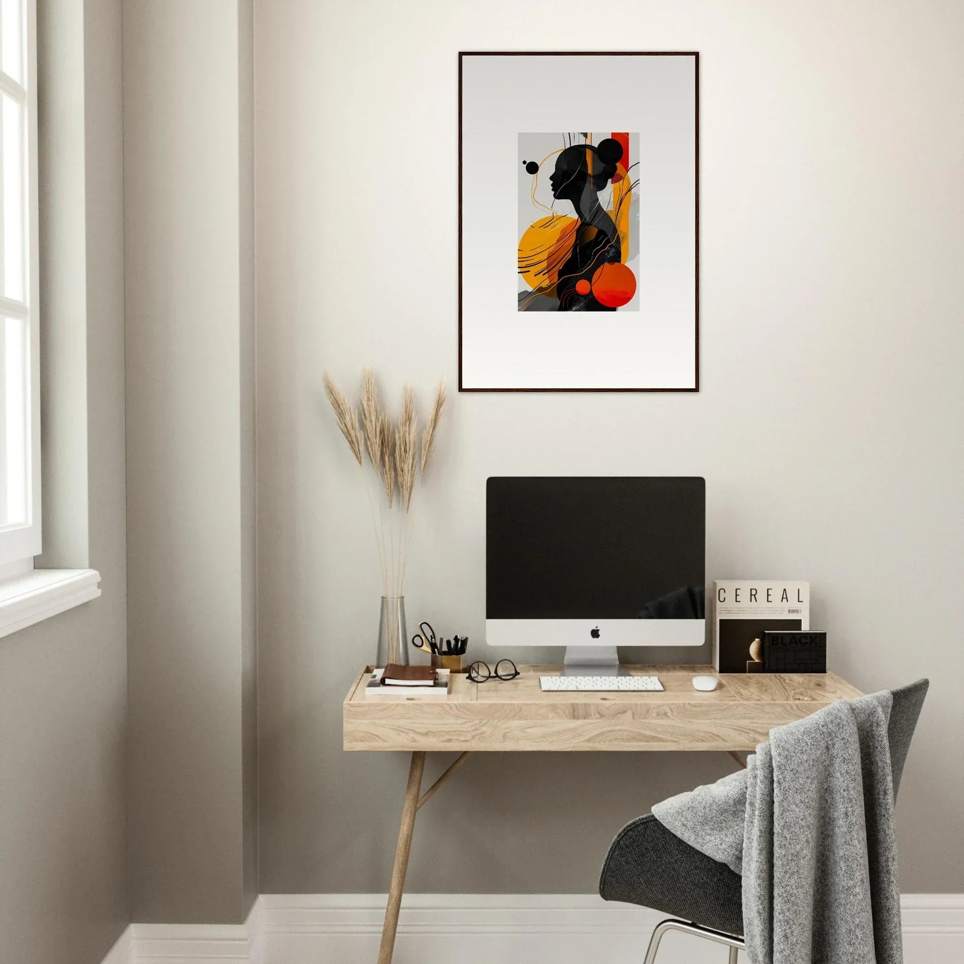 Modern home office with minimalist wooden desk, computer, and framed wall art decor