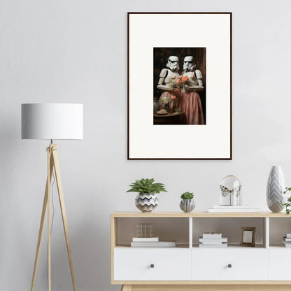 Framed black and white art of two figures in period dress enjoying a book together