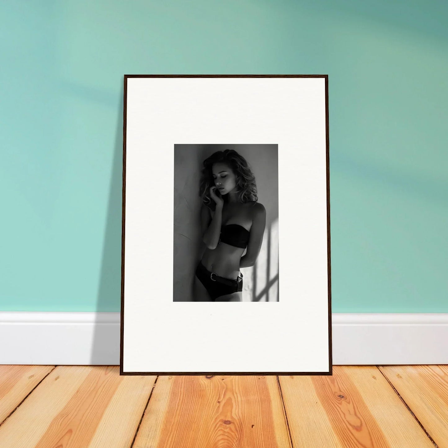 Framed black and white photograph of a woman in undergarments.