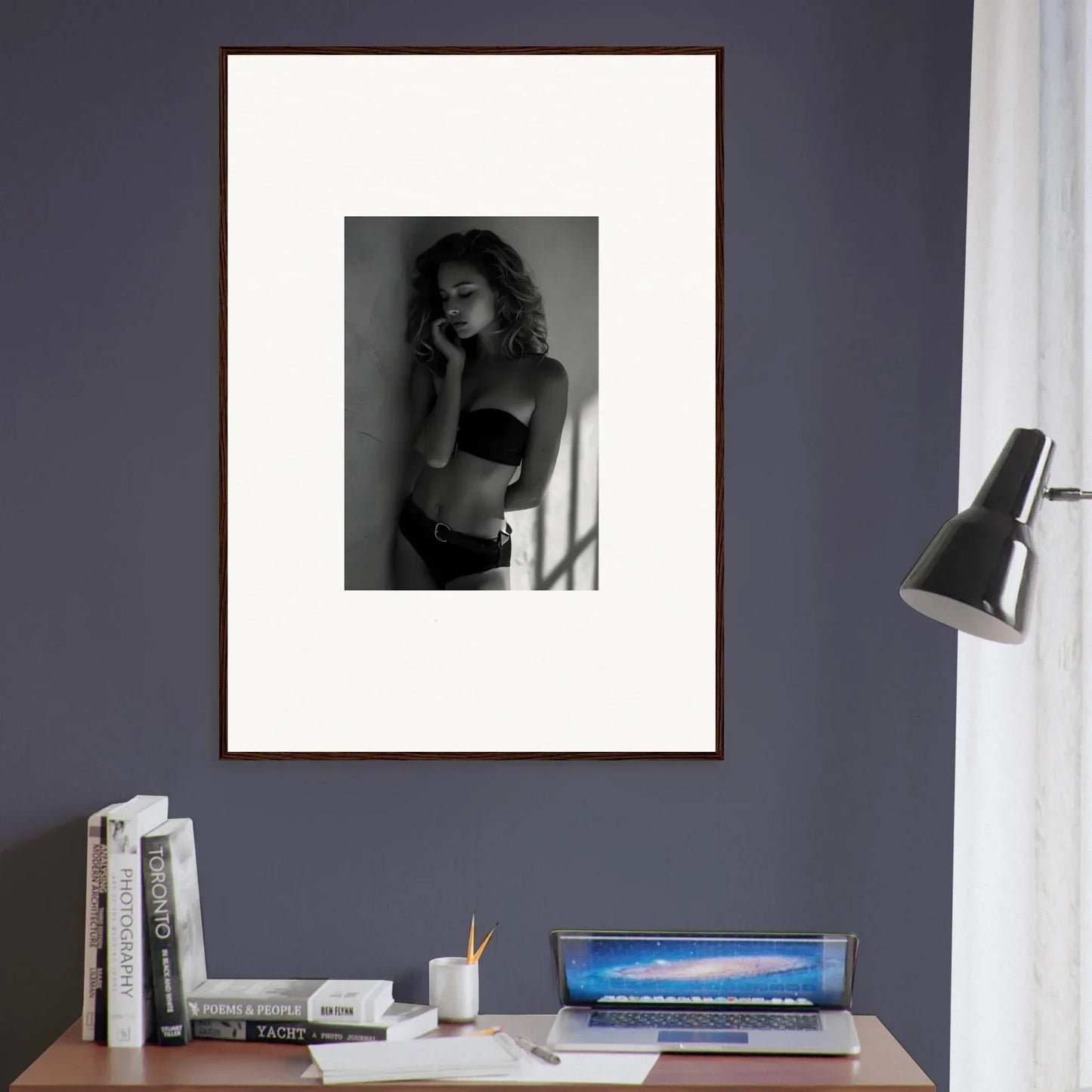 Framed black and white photograph of a woman in lingerie posing against a wall.