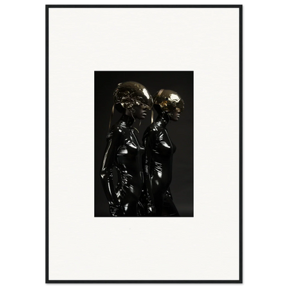 Framed black and white photograph of two shiny metallic figures standing close together.