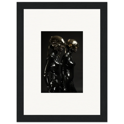 Framed black and white photograph of two shiny, metallic humanoid figures standing close together.