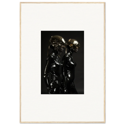 Dark metallic sculpture depicting two closely positioned figures with rounded forms.