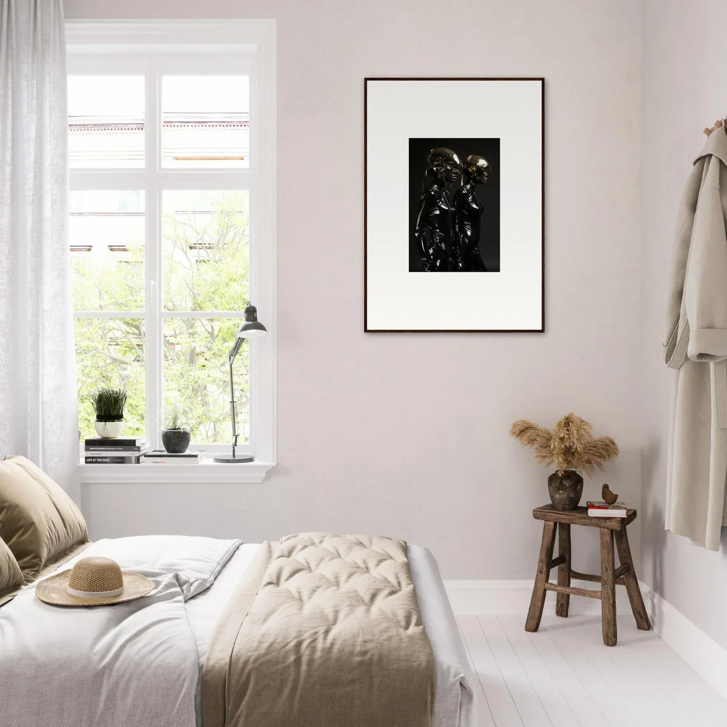 Cozy bedroom with light-colored decor and a framed artwork on the wall.