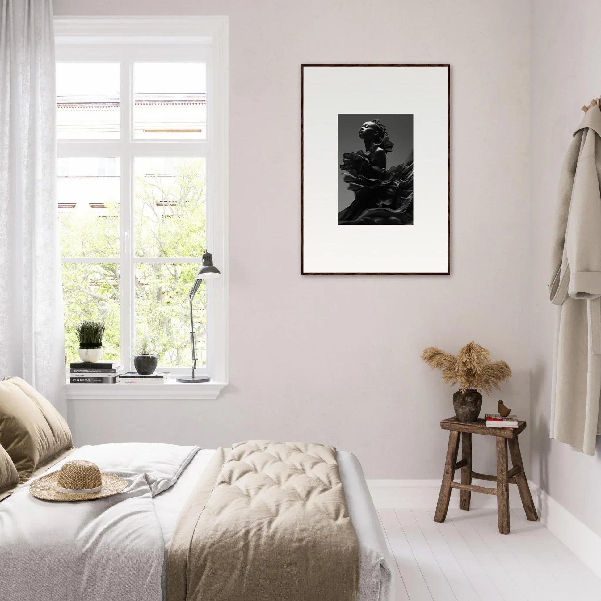 Bright, minimalist bedroom with a framed black and white photograph on the wall.