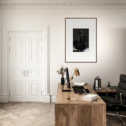 Wooden desk with various office supplies and a framed artwork above it.