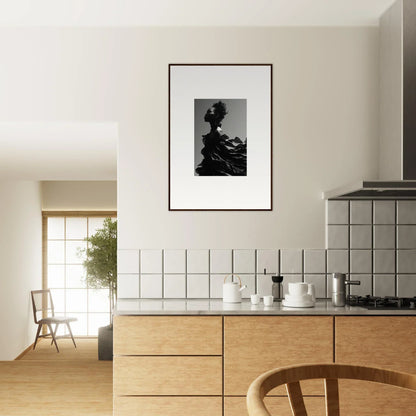 Modern kitchen with wooden cabinetry and a framed black-and-white photograph on the wall.