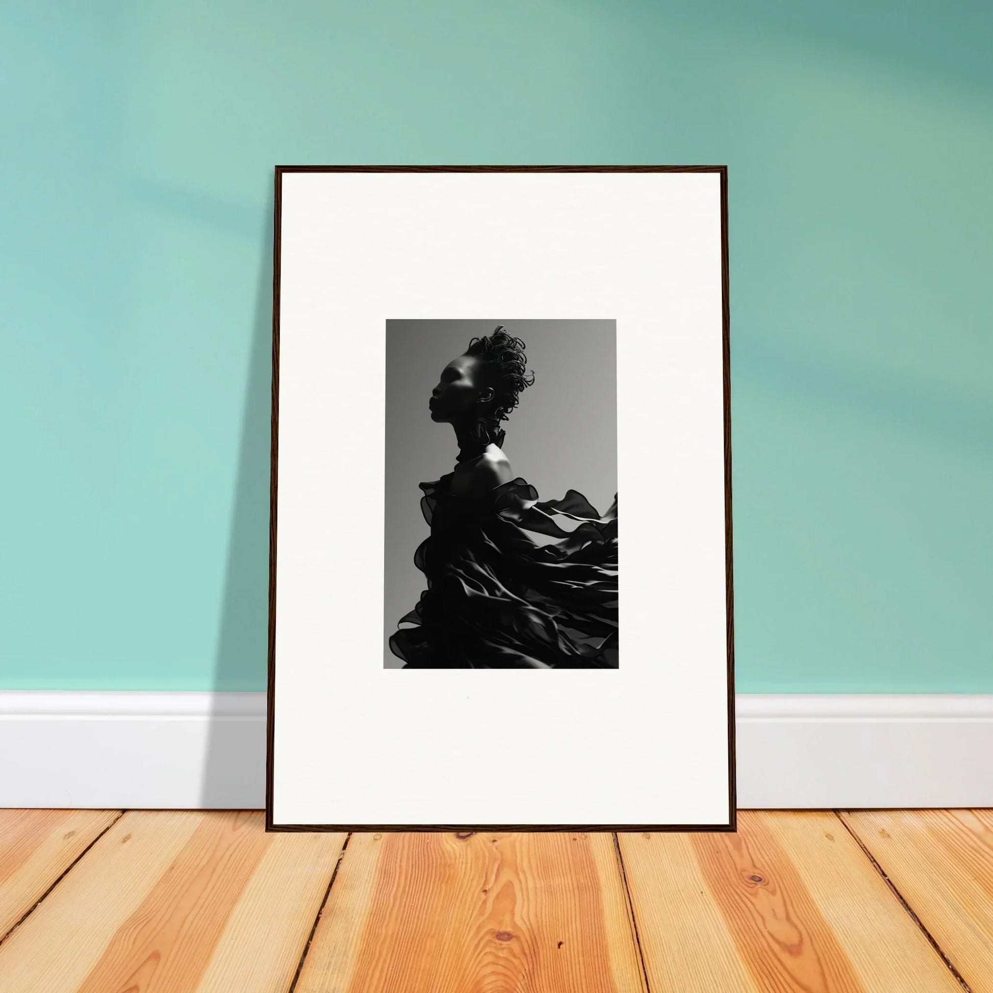 Framed black and white photograph of a silhouetted figure with dramatic hair and clothing.