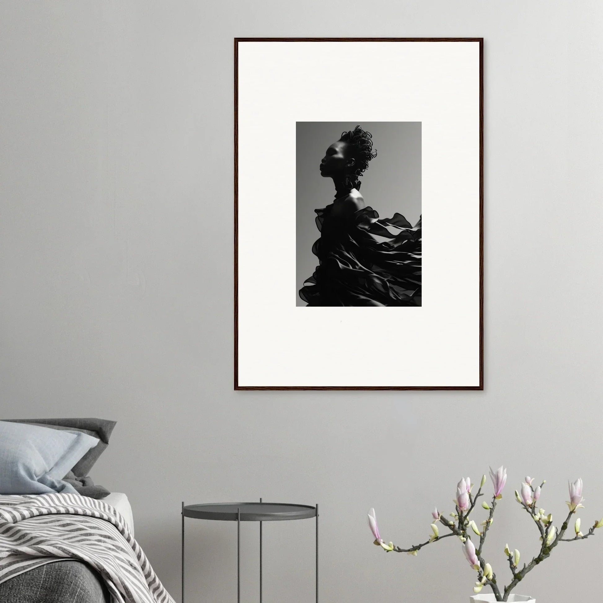 Framed black and white photograph of a silhouetted figure with an elaborate hairstyle and flowing garment.