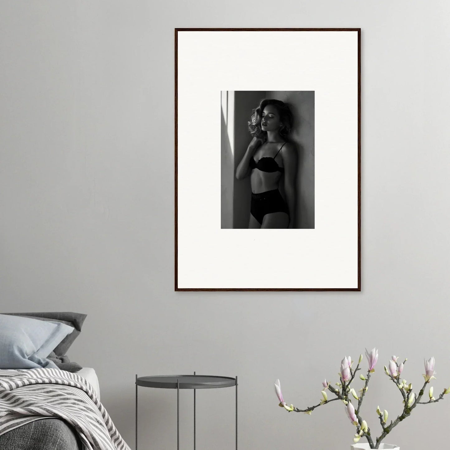 Framed black and white photograph of a woman in lingerie posing against a wall.