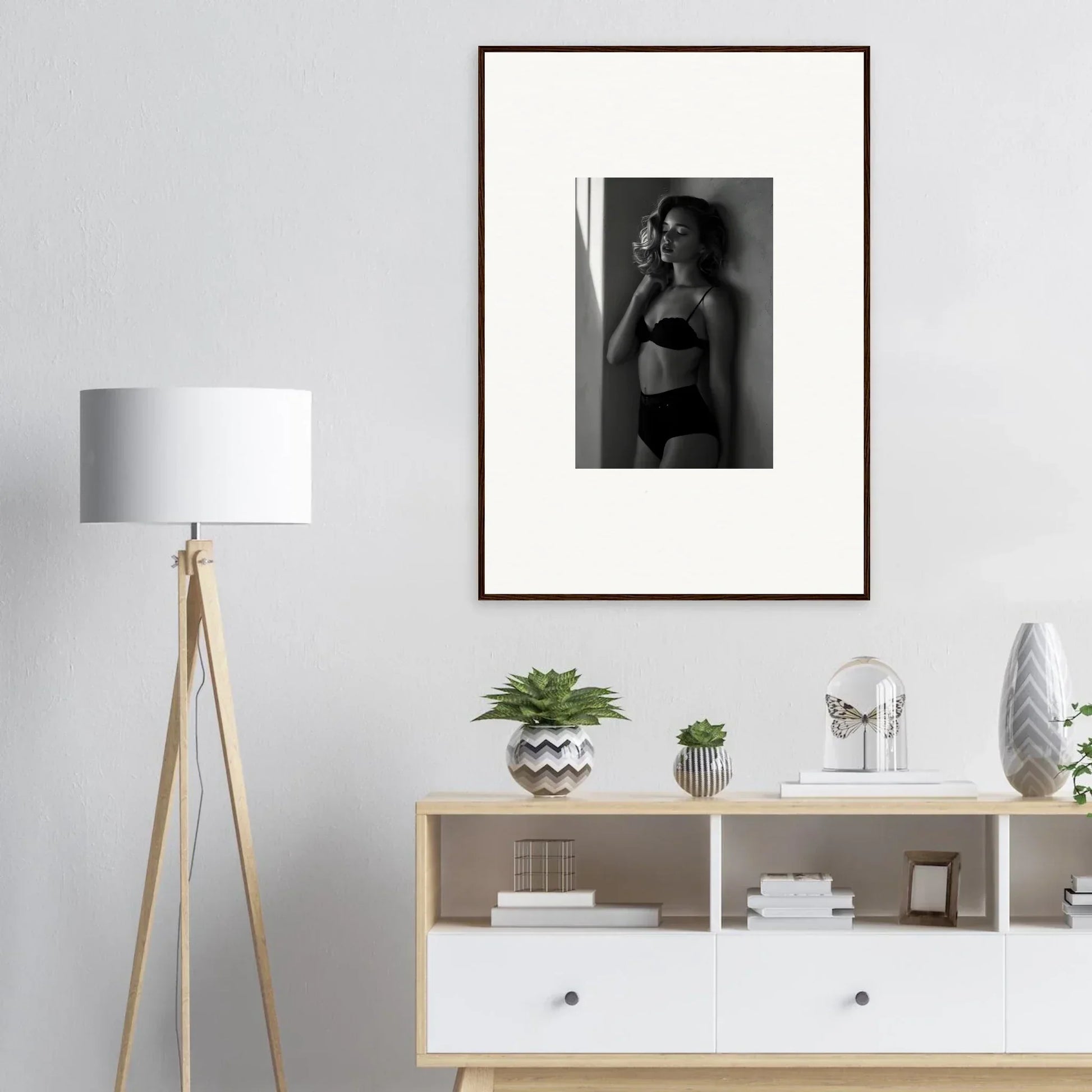 Framed black and white photograph of a woman in lingerie posing against a wall.