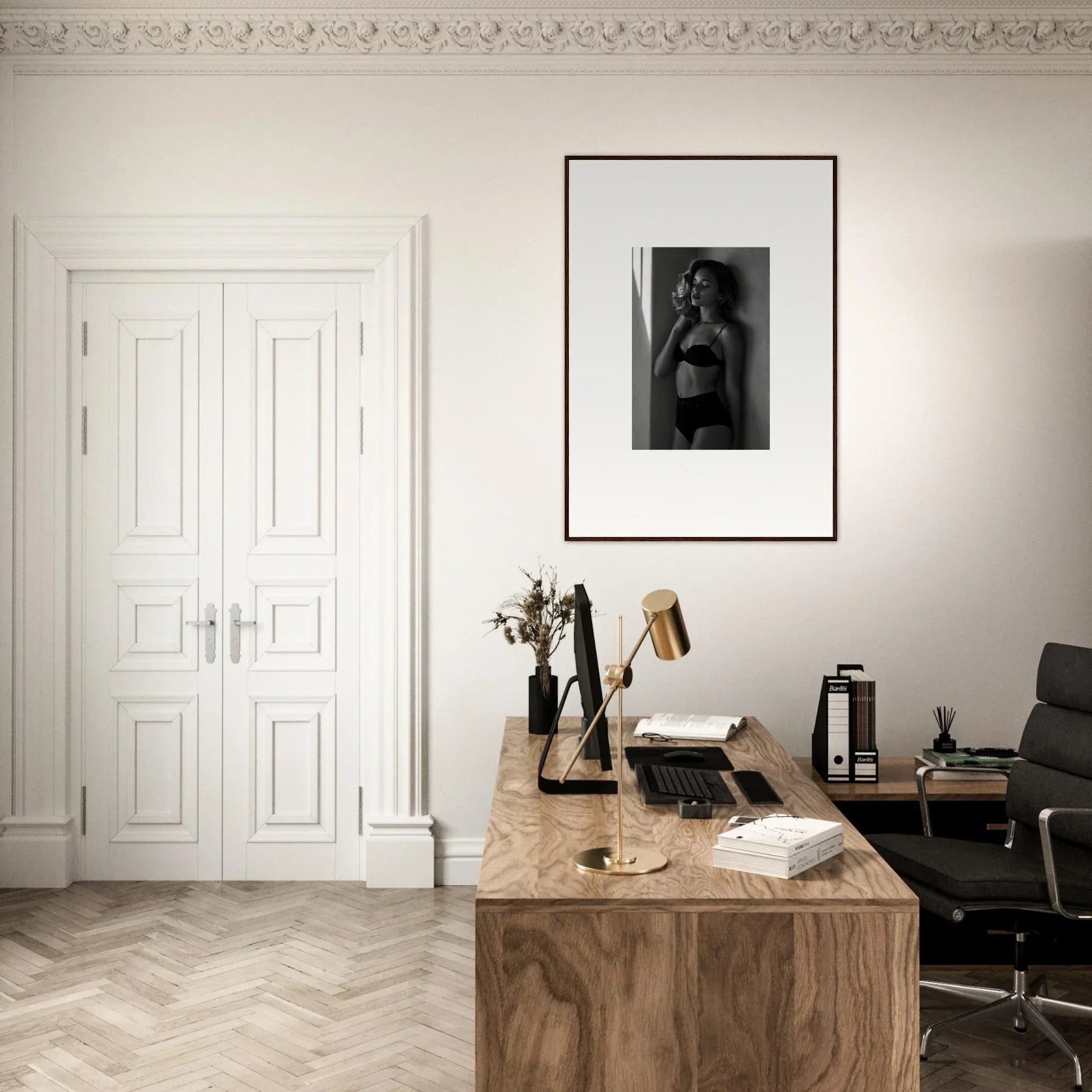 Wooden desk with various office items and a framed photograph on the wall above.