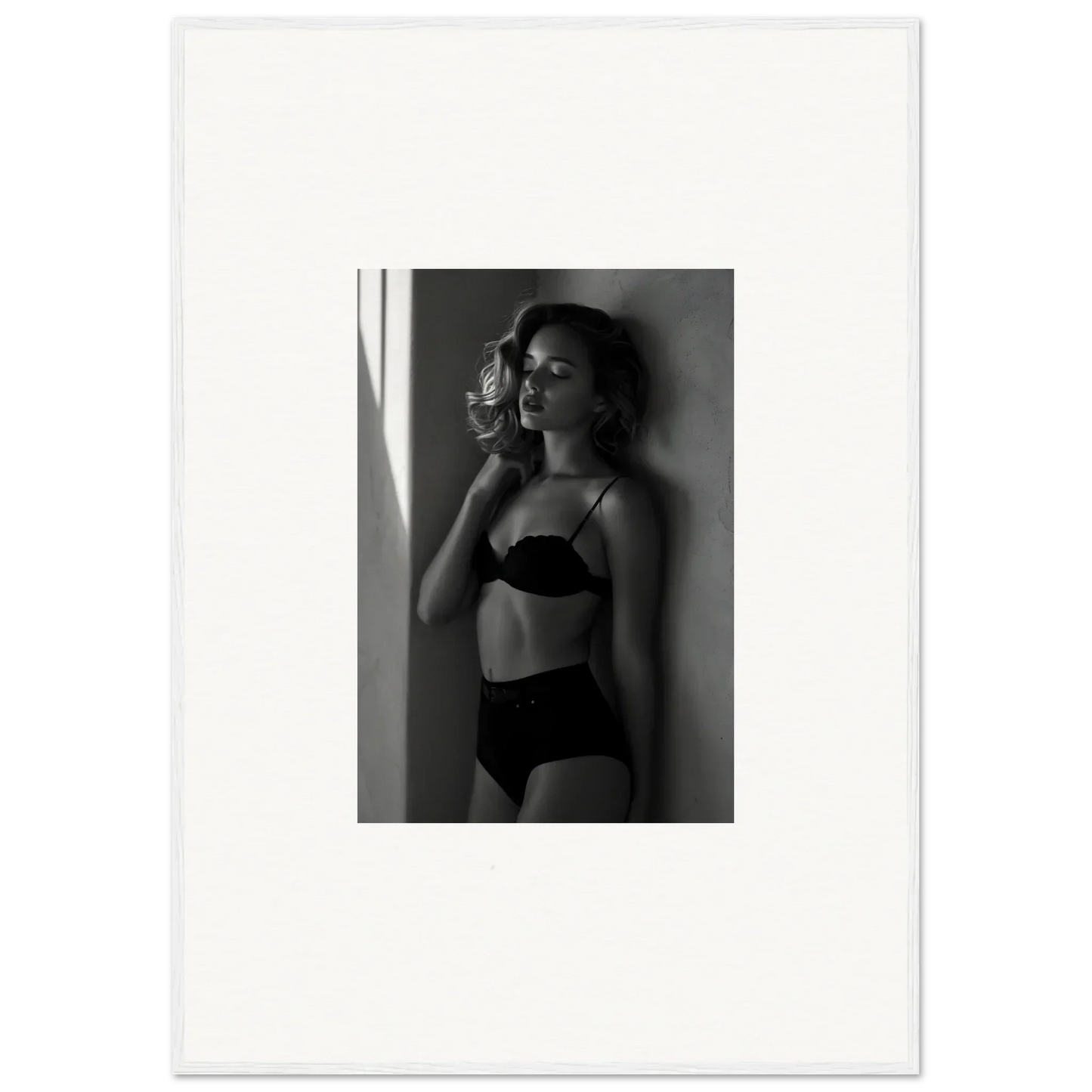 Black and white photograph of a woman in lingerie standing near a window.