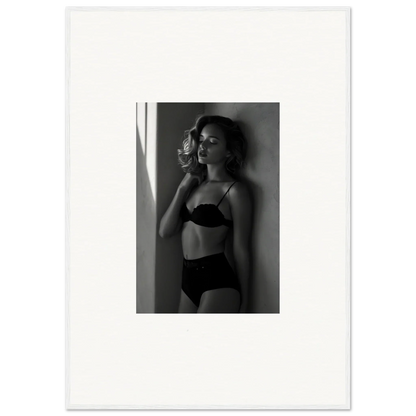 Black and white photograph of a woman in lingerie standing near a window.