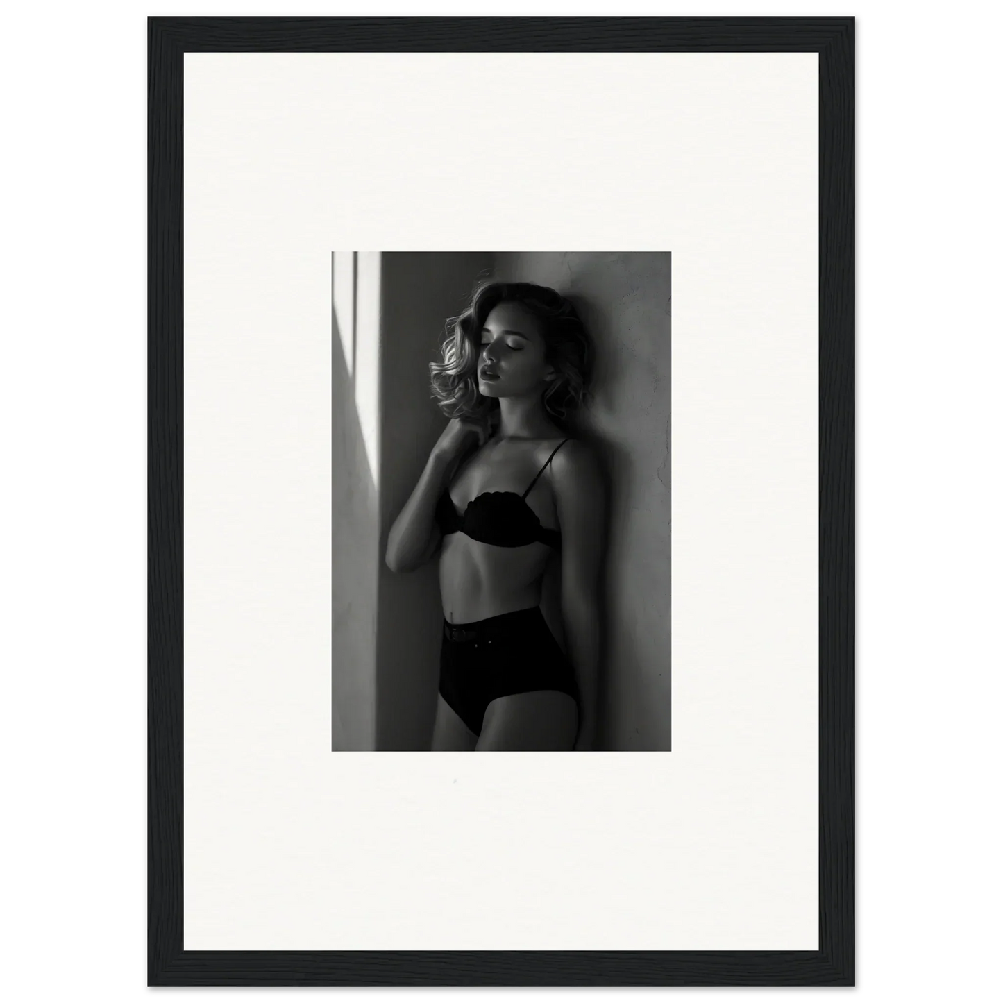 Black and white photograph of a woman in lingerie standing near a window.