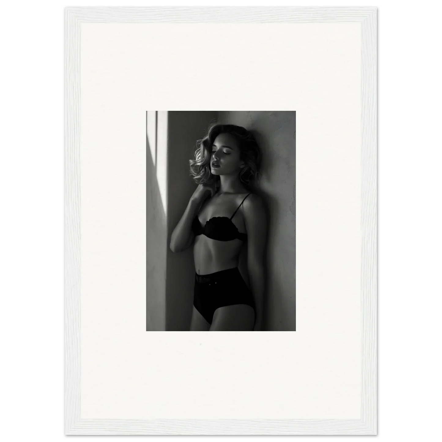 Black and white photograph of a woman in lingerie standing near a window.