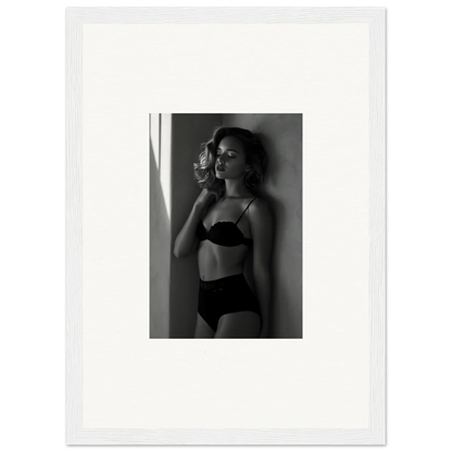 Black and white photograph of a woman in lingerie standing near a window.