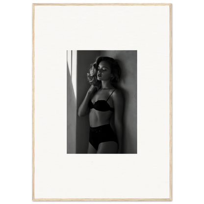 Black and white photograph of a woman in lingerie standing near a window.