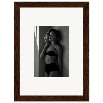 Framed black and white photograph of a woman in lingerie posing against a wall.