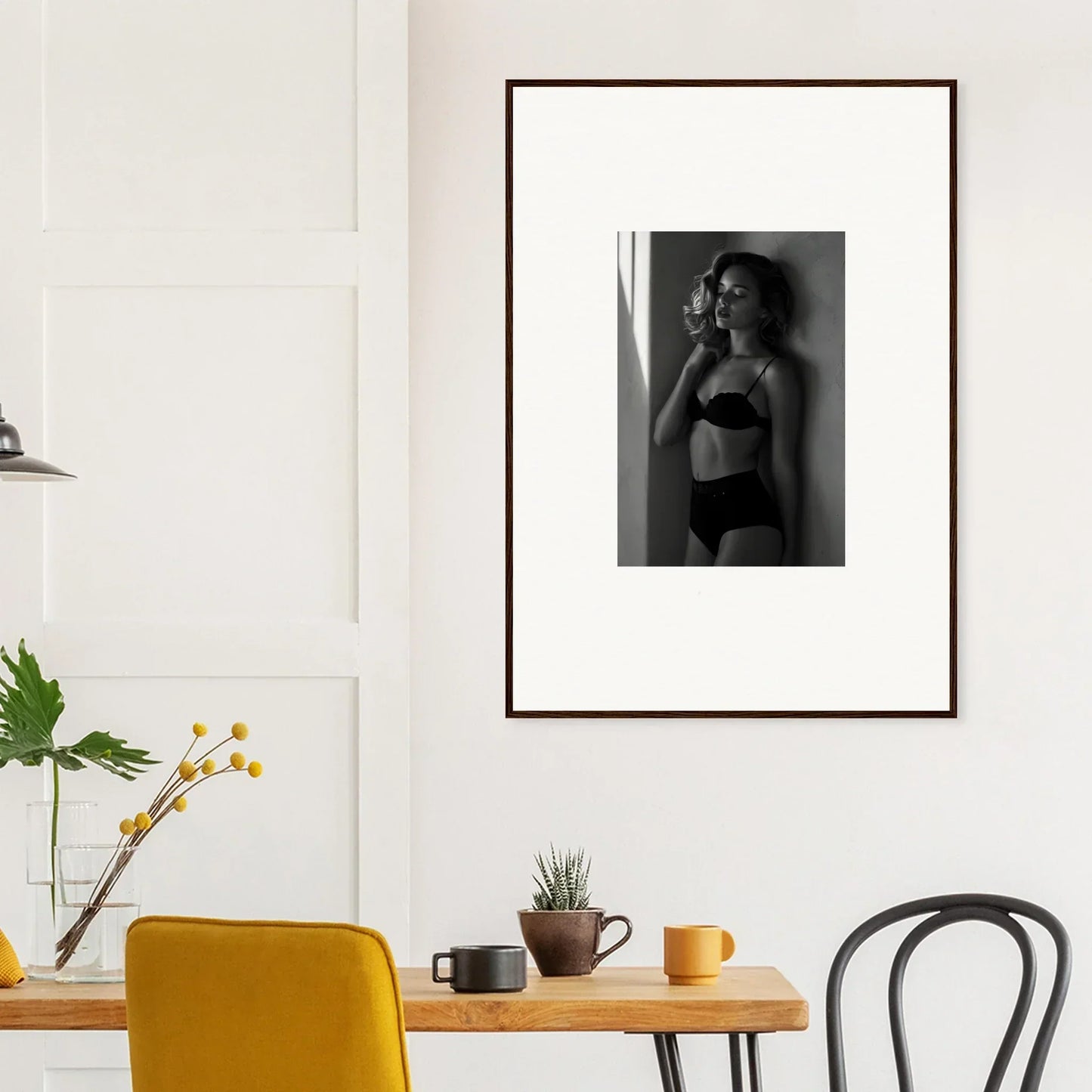 Framed black and white photograph of a woman in lingerie standing by a window.