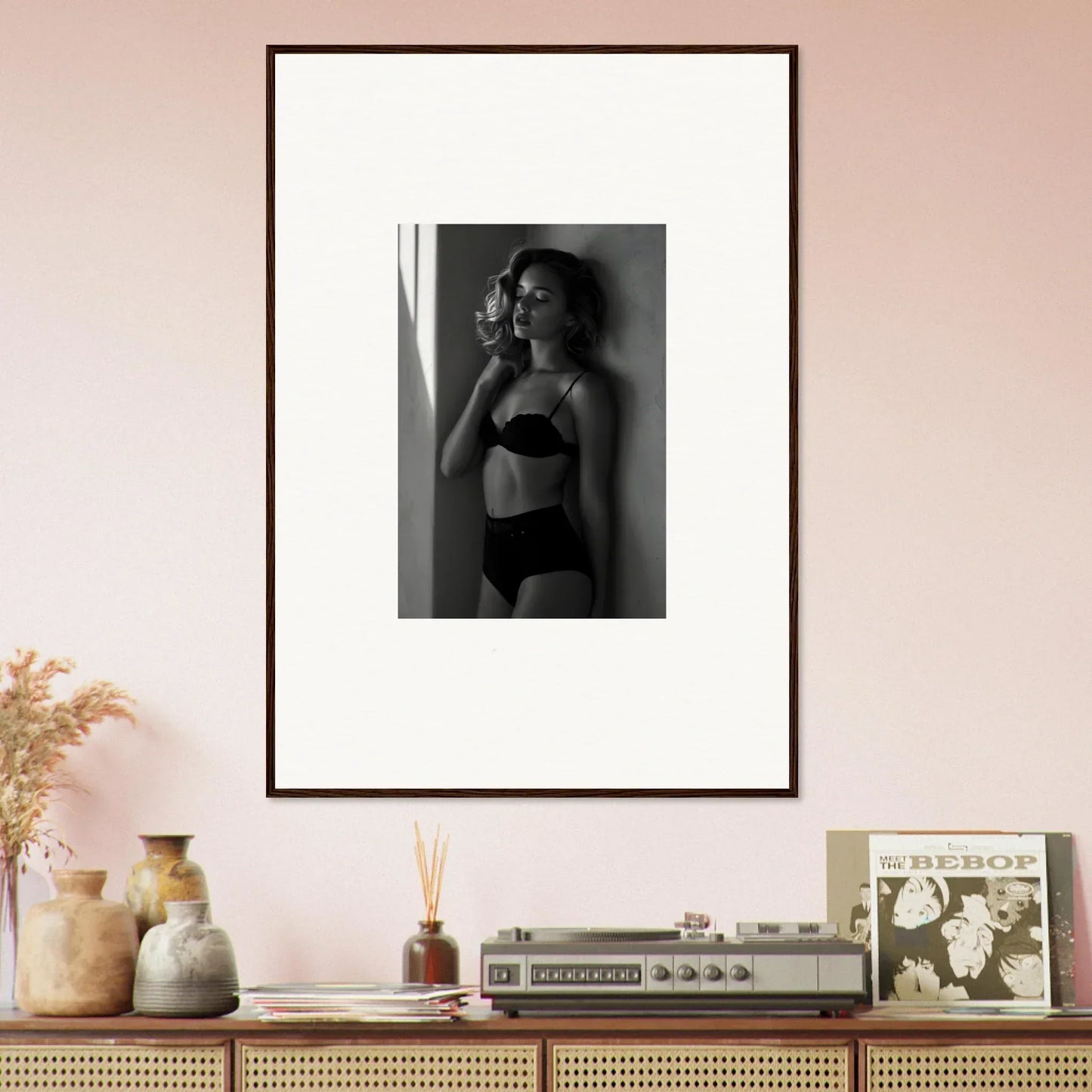 Framed black and white photograph of a woman in lingerie posing against a wall.