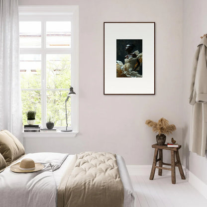 Bright, minimalist bedroom with neutral tones and a framed artwork on the wall.